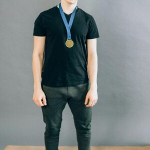 Man in Black Shirt Wearing a Gold Medal